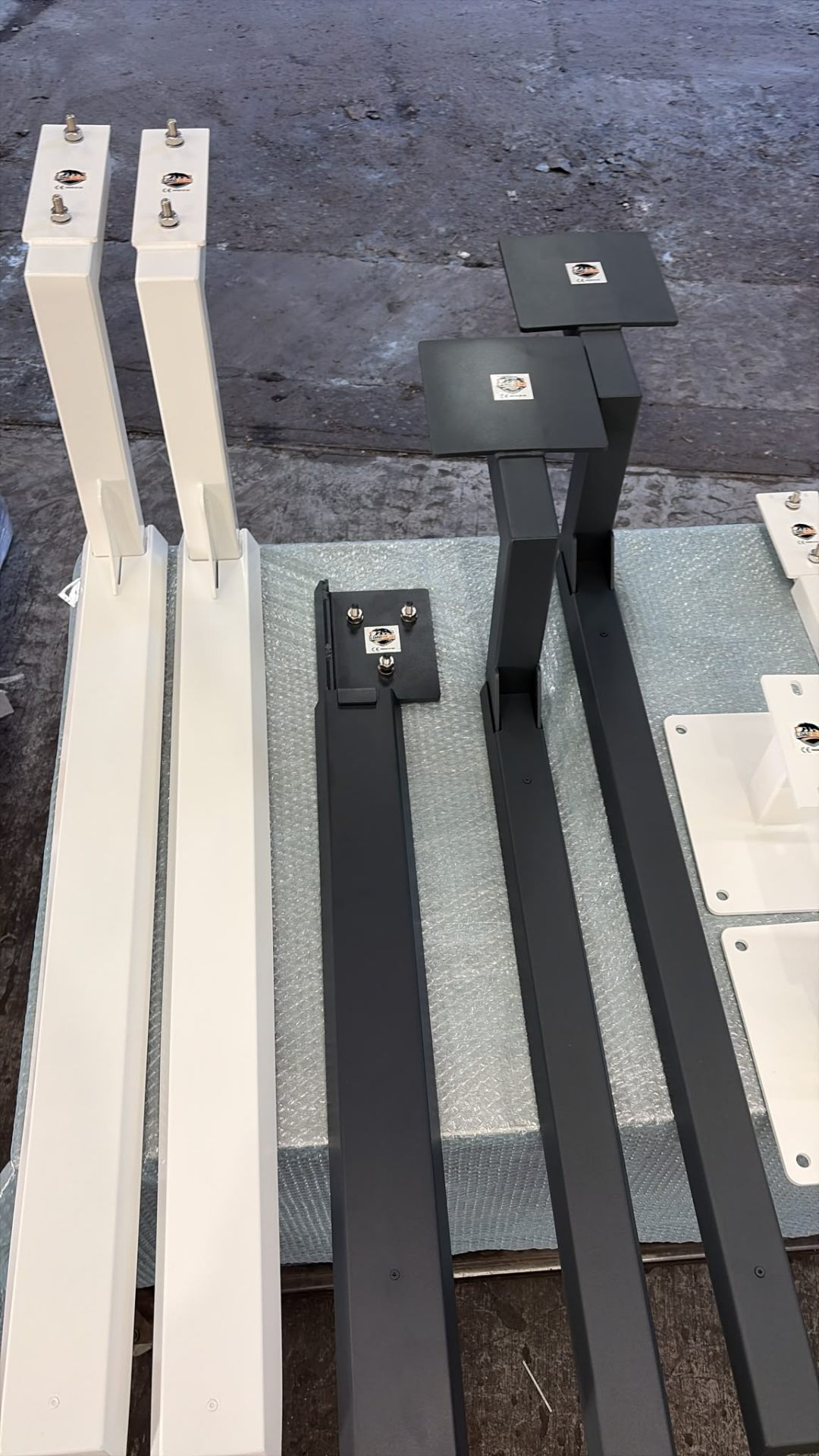 White and anthracite uprights side-by-side — bespoke stainless brackets