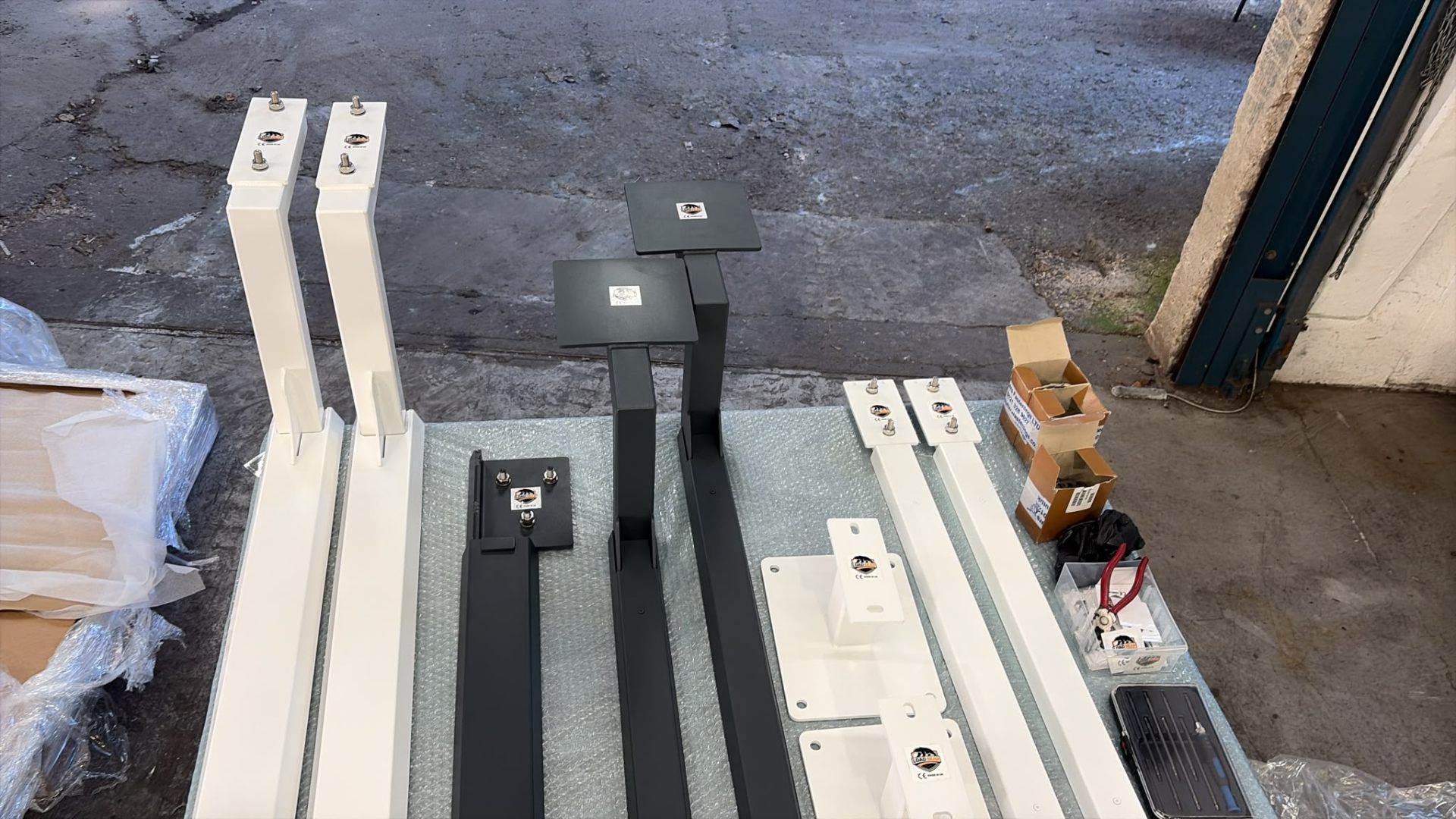 Full custom stainless steel awning bracket set laid out for inspection