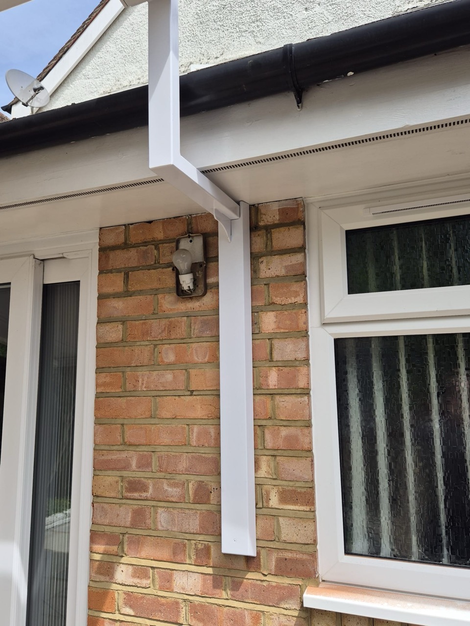 White aluminium awning support post with wall fixing bracket in situ