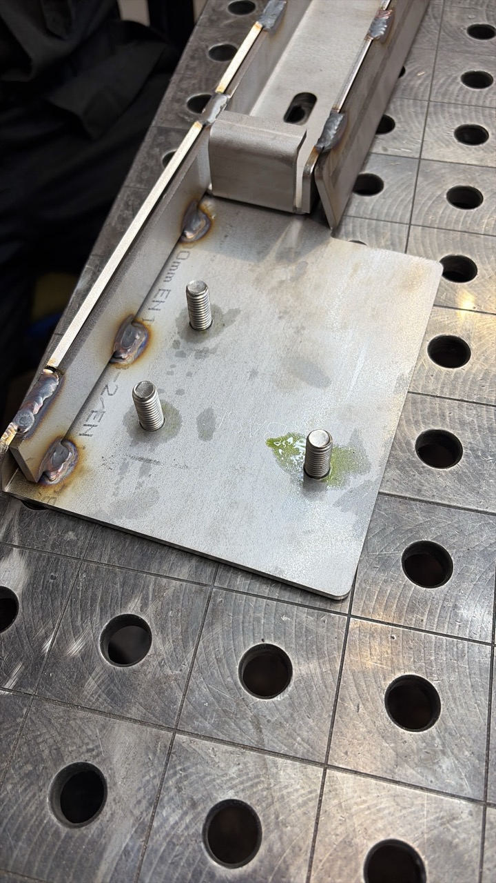 TIG welder running a bead on the bracket assembly