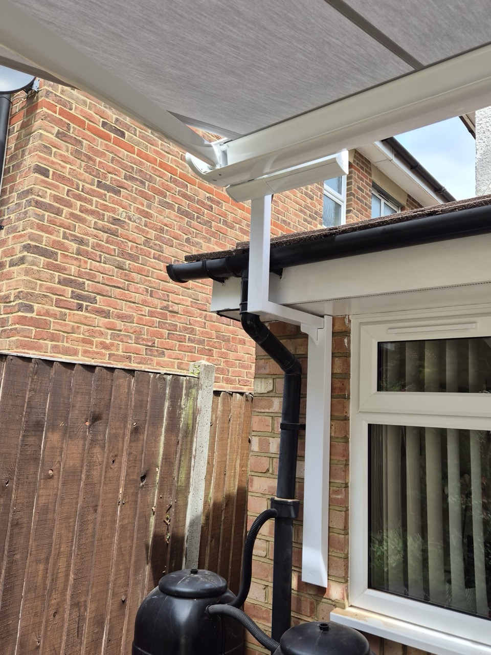 Aluminium awning canopy over a window and patio area, supported by LoadBear brackets