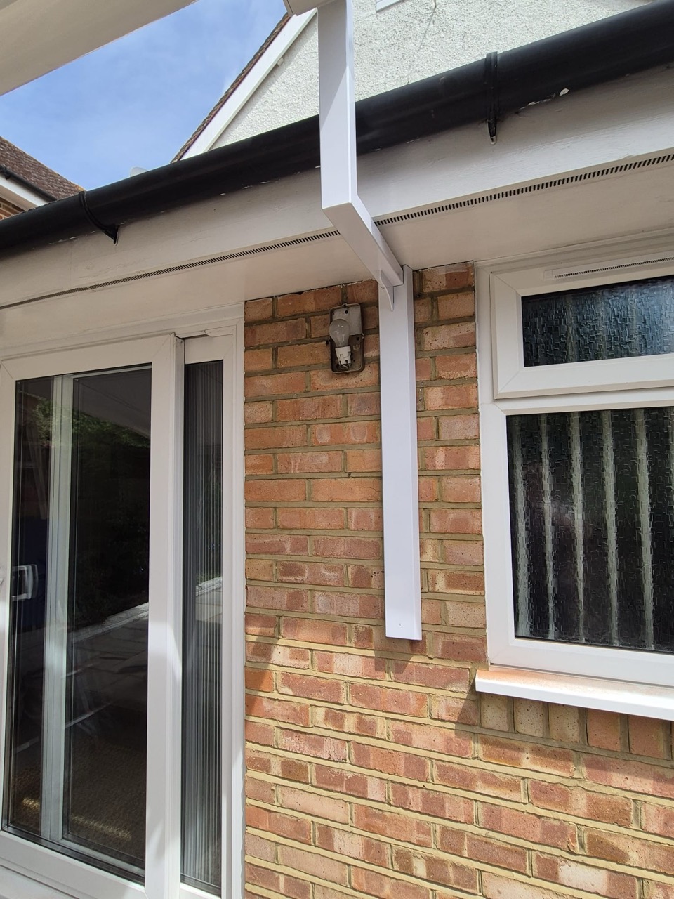 Aluminium awning canopy supported by LoadBear brackets over patio doors and windows