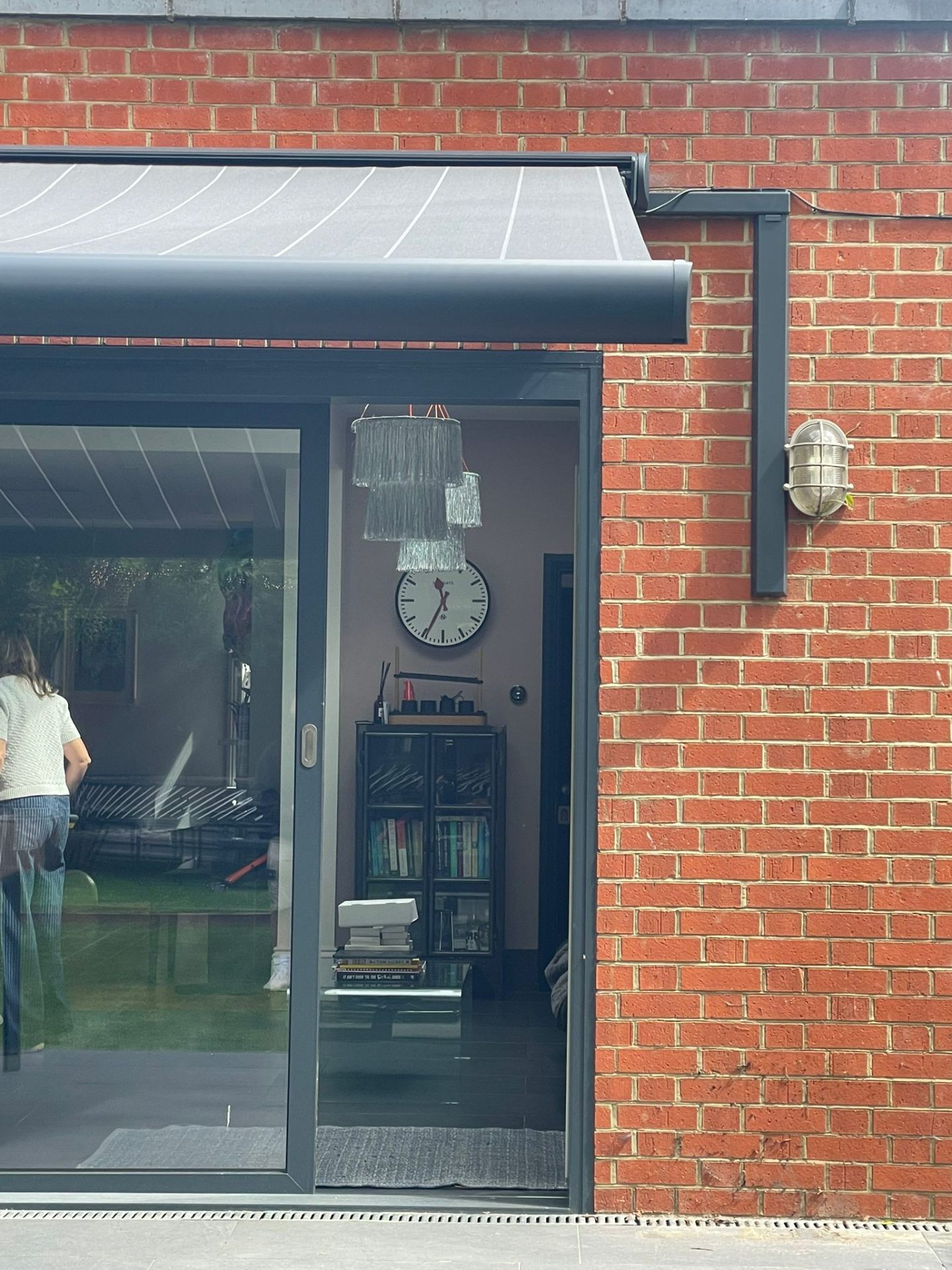 Awning extended — clean wall-mounted bracket detail on brickwork
