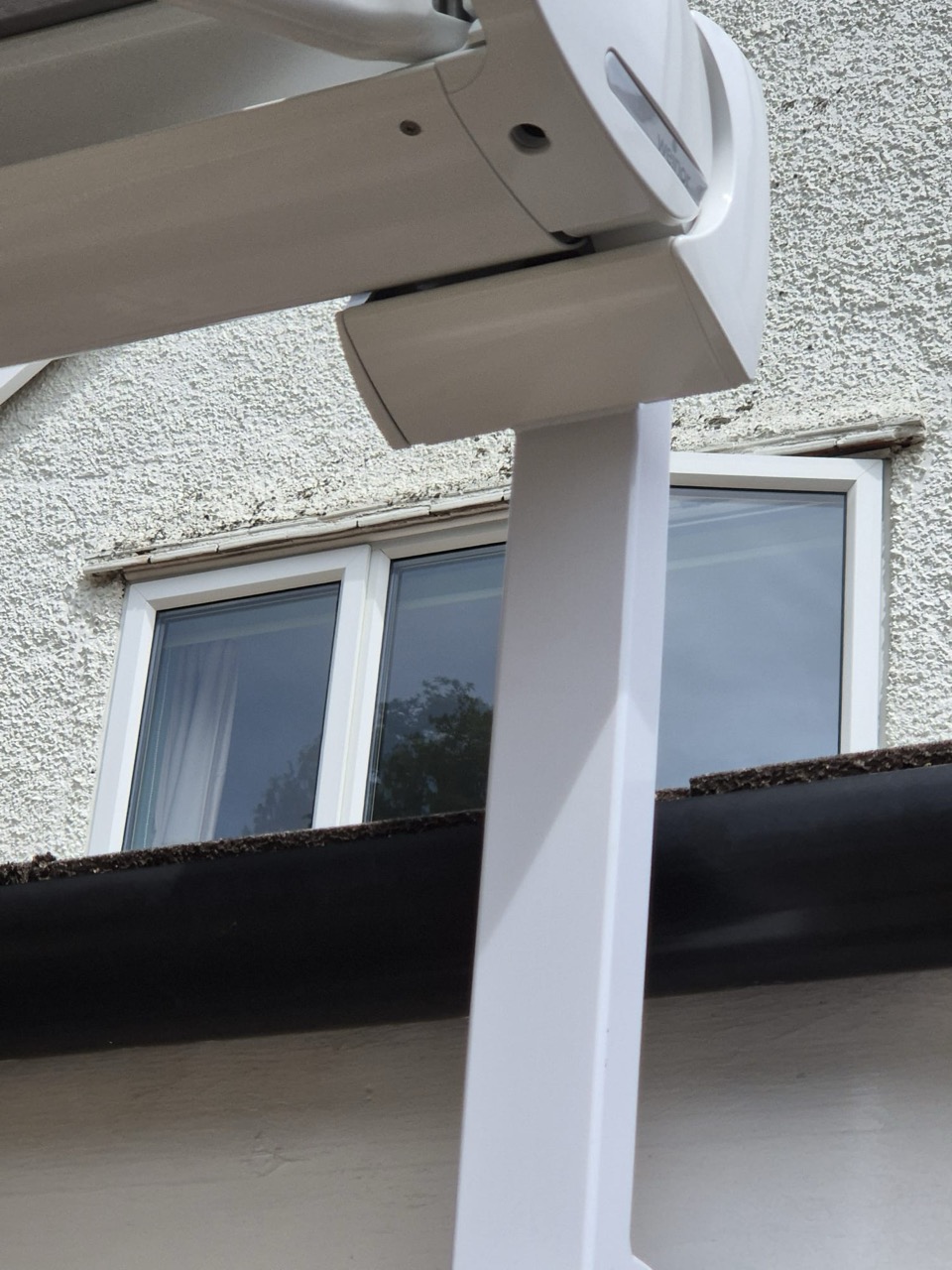 Stainless steel awning support post fixed to a brick wall with heavy-duty anchors