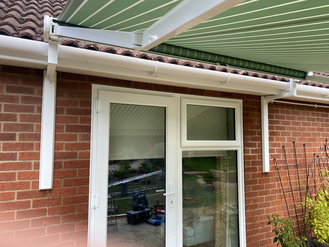Stainless steel gutter awning bracket carrying a cassette under a fascia