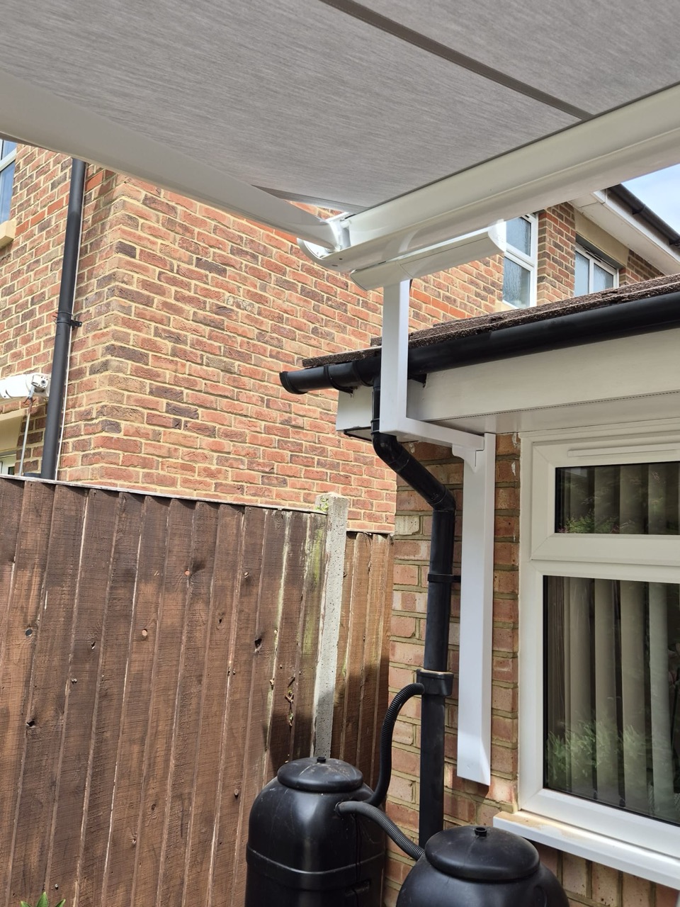 Aluminium awning canopy installed in a rear garden corner for outdoor shade